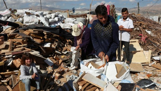 Syrští uprchlíci plní pytle odpadovým dřevem, které prodávají na táboráky v provizorním táboře v libanonském údolí Bikáa