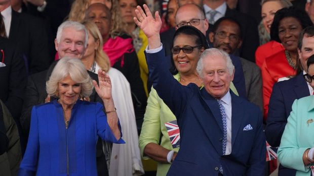 Král Karel III. a královna Camilla mávají lidem při příchodu na slavnostní koncert na hradě Windsor