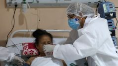 Zdravotníci pomáhají domorodé ženě nakažené novým koronavirem v nemocnici v brazilském Manausu
