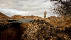 Ukrajinský voják hlídá čerstvě vykopaný zákop, který jeho jednotka vybudovala v rámci systému nových opevnění poblíž frontové linie u Kupjansku