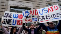 Protestující před budovou organizace USAID drží transparenty na její podporu
