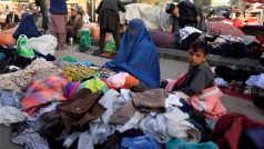 Afghánka a její syn rozprodávají své oblečení na ulici