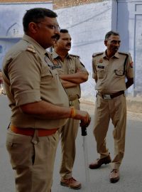 Policisté stojí na stráži před volební místností během třetí fáze parlamentních voleb v okrese Sambhal na severu indického státu Uttarpradéš
